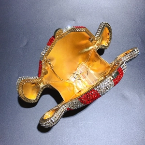 Detail view of open hippo evening clutch with red and white rhinestones and gold interior