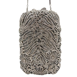 Detail of crystal clutch bag showing sparkling silver rhinestones and intricate floral pattern