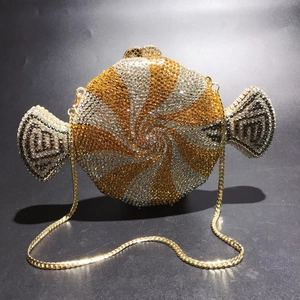 Detailed macro view of candy-shaped clutch bag with spiral crystal rhinestones and gold chain