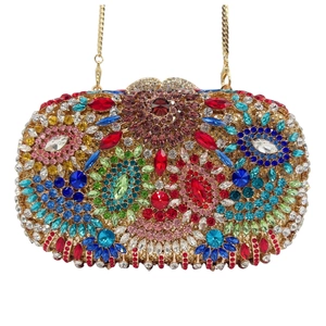Close-up of luxury gold evening clutch bag with colorful floral rhinestone patterns