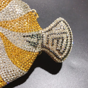 Macro shot of fish-shaped evening bag with gold and black rhinestones and metal ring