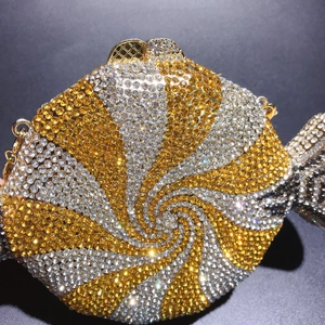 Detail of candy-shaped evening clutch with gold and white crystals and top square clasp