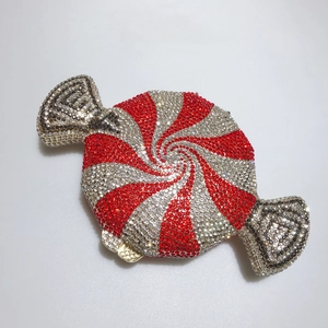 Macro shot of candy-shaped clutch bag with sparkling red and white spiral rhinestones