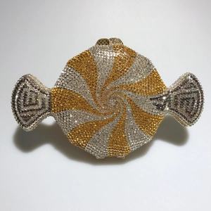 Macro shot of candy-shaped evening bag with gold and silver rhinestones and metal clasp