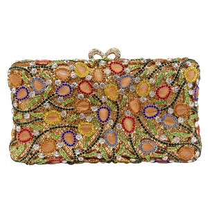 Detail of gold hollow evening bag with cat-eye stones and colorful rhinestones