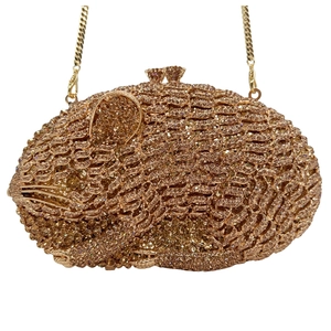 Macro detail of golden mouse-shaped evening clutch bag encrusted with sparkling rhinestones