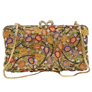 Detailed close-up of multi-colored gemstones and gold hollow-out mesh on evening bag