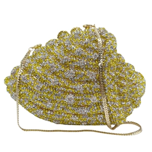 Detail of seashell evening clutch bag with sparkling yellow crystals and gold chain strap