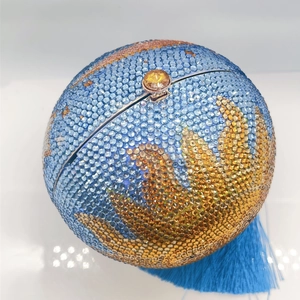 Detailed view of spherical evening bag with world map rhinestones and blue tassel