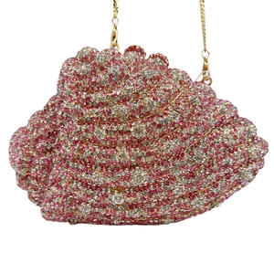Detailed macro view of gradient pink and white rhinestones on conch shell clutch bag
