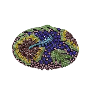 Macro detail of oval clutch bag with vibrant floral pattern and multi-color rhinestones