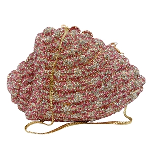 Macro shot of conch shell evening clutch bag with pink and white rhinestones and gold chain