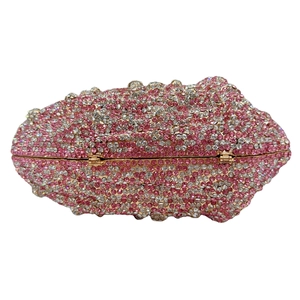 Macro detail of luxury pink rhinestone conch clutch with golden hinge and sparkling crystals