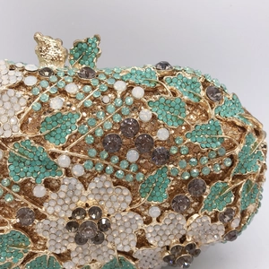Macro detail of intricate floral crystal patterns on luxury gold evening clutch bag