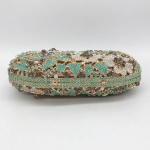 Macro detail of luxury evening clutch featuring mint green and white floral rhinestones