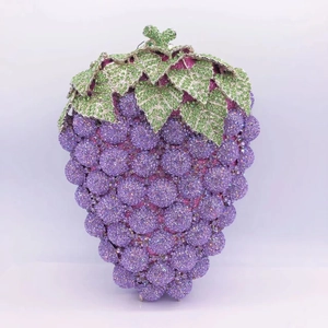 Detailed view of luxury grape-shaped clutch featuring purple crystals and green leaf details