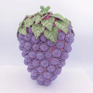 Detail of grape-shaped evening clutch featuring purple crystals and green leaf accents