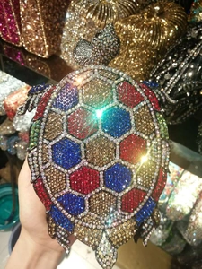 Detail of crystal turtle clutch bag featuring colorful hexagonal rhinestones and metal frame