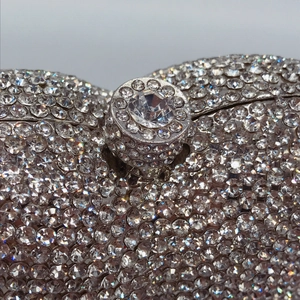 Macro shot of silver crystal rhinestones and diamond-studded clasp on evening clutch bag