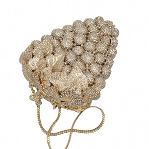 Macro view of gold grape-shaped evening clutch featuring dense rhinestone setting and leaf detail
