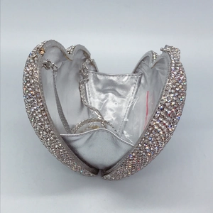 Detail of silver heart clutch with rhinestones, silver leather lining and chain strap