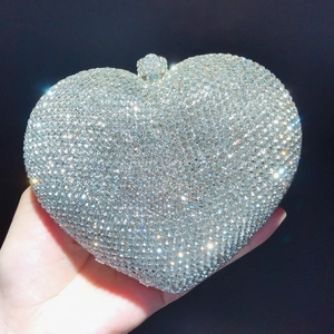 Detail of silver heart evening clutch bag with sparkling crystals held in hand