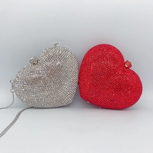 Detailed view of silver and red heart-shaped crystal clutch bags with chain straps
