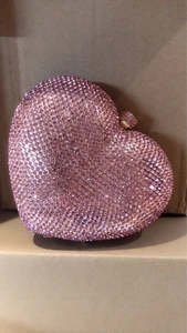 Detailed view of heart-shaped evening bag with pink rhinestones and gold clasp