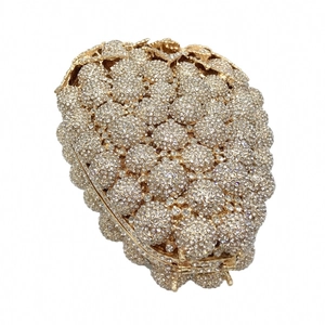 Detailed view of grape crystal evening clutch with sparkling rhinestones and gold leaf closure