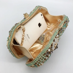 Green and grey crystal clutch bag with gold frame and chain strap in a 45-degree view