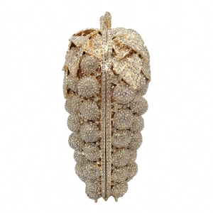 Detailed view of the sparkling rhinestone grapes shape and metallic leaf on the evening clutch