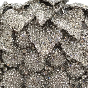 Macro shot of silver evening clutch featuring grape leaf design and sparkling rhinestones