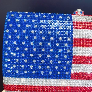 Macro shot of dense rhinestones forming the American flag pattern on a luxury clutch