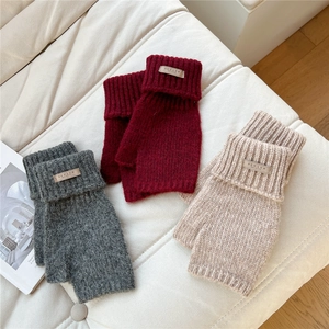 Detailed knit texture of warm fingerless gloves in grey, red, and beige colors
