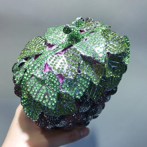 Detailed macro view of the crystal grape clutch showing vibrant green and purple rhinestones