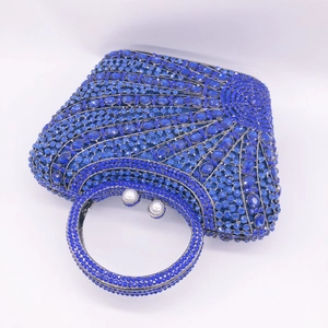 Macro view of blue crystal rhinestones and pearl clasp on luxury evening clutch bag