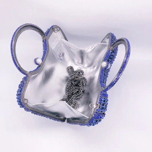 Detailed interior of blue rhinestone clutch with silver chain and pearl handles