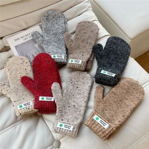 Thick knit woolen mittens in various colors with speckle patterns and fashion labels