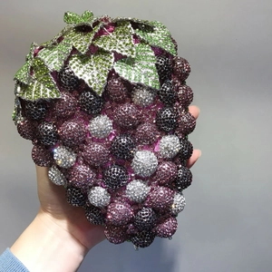 Detailed view of handmade grape crystal clutch with purple rhinestones and green leaf decor