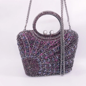 Macro detail of fan-shaped clutch with purple rhinestones and pearl clasp closure