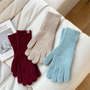 Three pairs of knit gloves in burgundy, beige, and light blue with ribbed cuffs