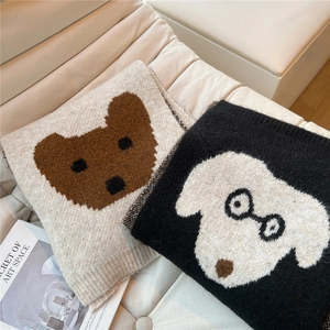 Dettaglio della sciarpa in morbida maglia con motivi jacquard animali in beige e nero