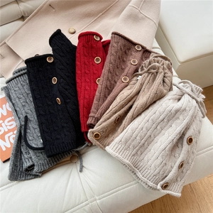 Detail showing various colors of cable-knit neck warmers with decorative wood buttons