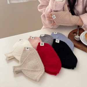 Gros plan détaillé de mitaines en tricot doux en couleurs pastel avec étiquettes de marque
