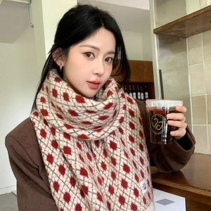 Gros plan d'une écharpe en tricot à losanges rouge et noir au toucher doux
