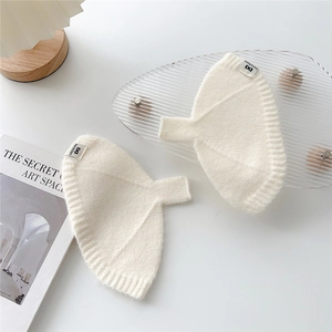 Détail de la texture tricotée blanche et de l'étiquette de marque sur gants thermiques