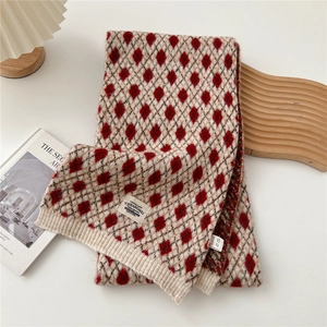 Détail de l'écharpe en tricot à losanges rouge et blanc avec texture douce et étiquette