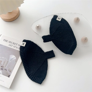 Gants en maille noirs sans doigts avec bords-côtes et étiquette de marque en gros plan