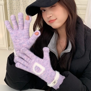 Détail du gant en tricot violet clair avec motif D et fentes pour doigts tactiles