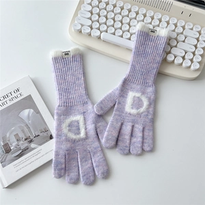 Détail de gants en tricot violet clair avec lettre D en peluche et poignets en fausse fourrure